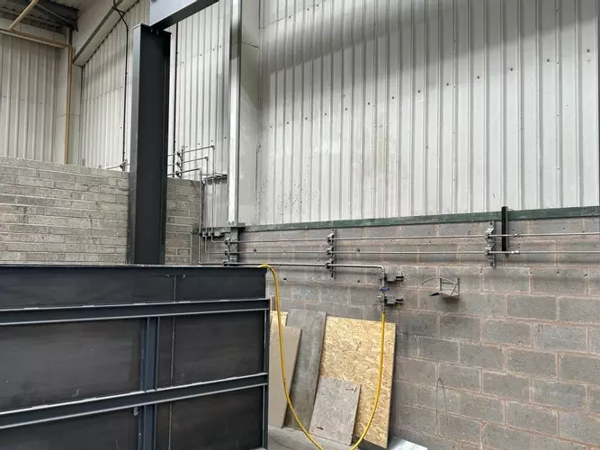 Part of the new pipework infrastructure installed at the Tamworth facility. This section shows three stacked pipework runs routed through the building &mdash; two high-pressure lines supplying the wash bay and one low-pressure feed serving the pressure washin